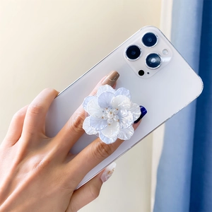 Detail view of a 3D floral phone grip with pearlescent purple petals and a pearl center