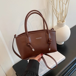 Sac à main carré marron foncé avec texte mode et détail de poignée nouée