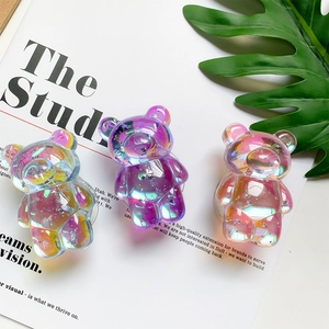 Close-up of three iridescent laser bear phone grips with silver foil on a white magazine