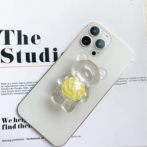 Gros plan d'un support de téléphone en forme d'ours avec motif tourbillon jaune vif