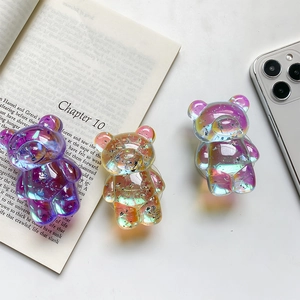 Detailed view of three 3D laser gradient bear phone grips with silver glitter effect