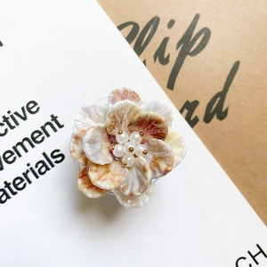 Detailed macro view of the marble-textured cream flower phone grip with pearl accents