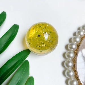 Detail of transparent crystal ball phone grip with elegant gold and silver foil filling