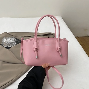 Sac à main en cuir rose avec poignées nouées et texte Fashion argenté sur fond blanc