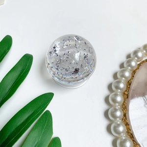 Close-up of a transparent crystal ball phone socket with silver foil and rainbow halo