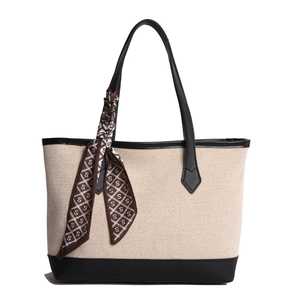 Large beige canvas tote bag with black leather trim and decorative printed silk scarf