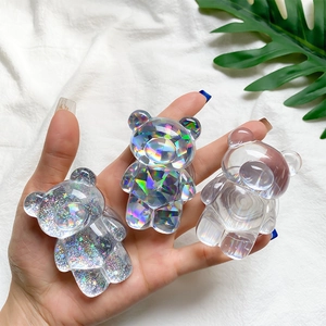 Close-up of three sparkling bear-shaped phone griptoks held in hand with shiny finishes