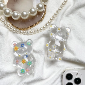 Detail view of two cute clear resin bear phone grips with colorful floral patterns
