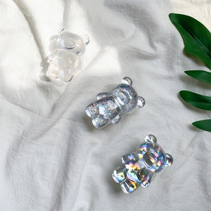 Three cute bear-shaped phone grips in transparent, glitter silver, and holographic finishes