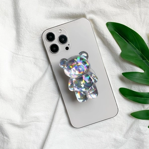 Iridescent 3D bear pop socket grip for smartphone shown on white aesthetic fabric