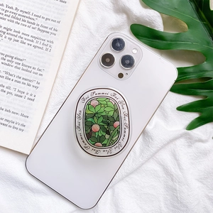 Floral letter phone grip holder with green mosaic plant design on a white smartphone