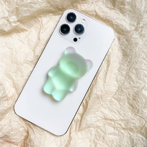 Vue détaillée d'un support de téléphone ours vert mat sur un smartphone blanc