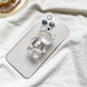Floral resin bear phone grip on white smartphone against textured fabric backdrop
