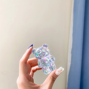 Macro view of a colorful holographic resin bear phone grip held by hand for display