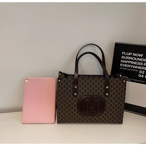 Detailed view of brown monogram tote bag size comparison with a 10-inch pink tablet