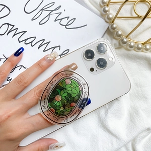 Detailed view of a green floral alphabet phone socket on a white smartphone back