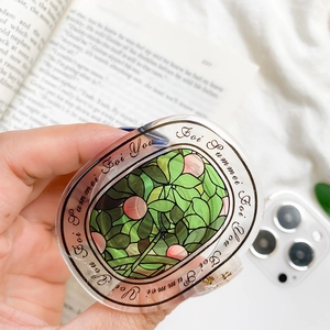 Close-up of clear acrylic phone grip with green leaf art and artistic window pattern