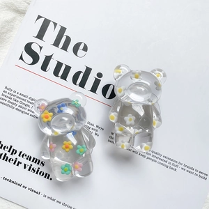 Detailed close-up of cute bear-shaped phone grips with colorful floral resin patterns