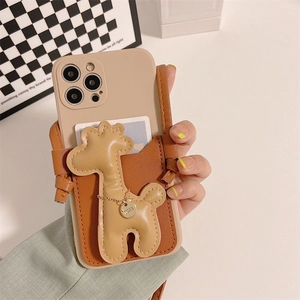 Détail de la coque iPhone avec design girafe 3D, base silicone beige et pendentif doré