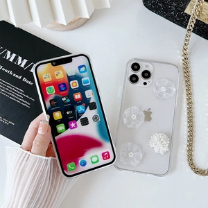 Détail de coque iPhone transparente avec fleurs 3D et perles élégantes en relief