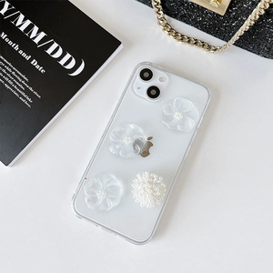 Détail de la coque iPhone transparente avec fleurs en résine 3D et perles blanches