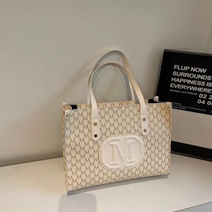 Classic white tote bag with repeated M-pattern prints and embossed round logo detail