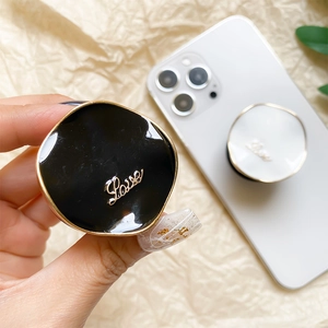 Minimalist LOVE metal phone grip stand in black and white with golden finish accents