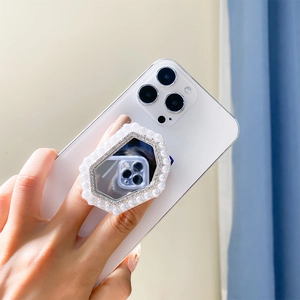 Dettaglio supporto specchio ottagonale con perle e strass su smartphone bianco