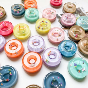 Detailed view of colorful resin donut phone grips with glitter filling and diverse candy tones