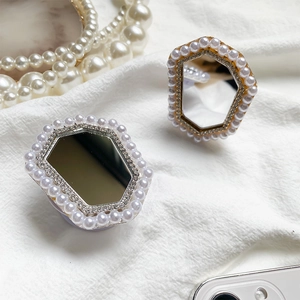 Dettaglio del supporto per telefono con perle e strass e mini specchio per trucco