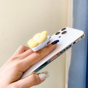 Detail of yellow flower phone grip with folding socket shown held in hand for scale
