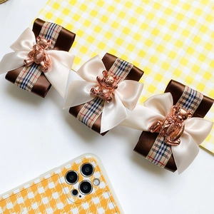 Detailed view of three layered bow phone stands with cute 3D metallic bear accents