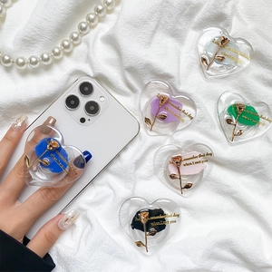 Close-up of heart-shaped phone grips with metallic roses in diverse pastel colors