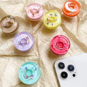 Close-up of colorful doughnut phone grips with 3D sprinkle details on textured paper