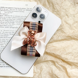Chic rose gold bear phone stand with vintage ribbon bow on a white smartphone
