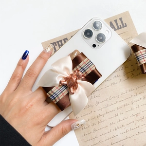 Bowknot bear phone grip holder with plaid ribbon and rose gold metal bear on cream fabric