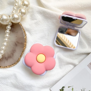 Pink flower-shaped portable phone stand with a built-in makeup mirror and yellow center