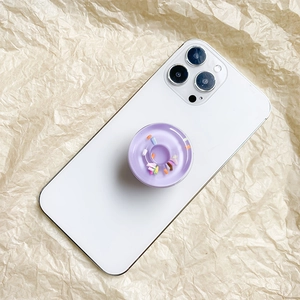 Detailed close-up of a purple doughnut phone grip on a white smartphone device