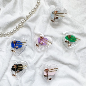 Flat lay of heart-shaped phone grips with gold roses on white wrinkled fabric