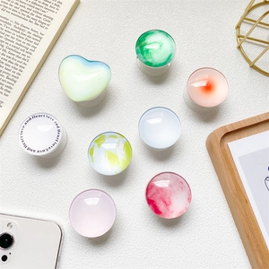 Flat lay of diverse marble and laser glass patterns on expandable phone grip sockets