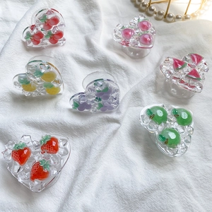 Macro shot of heart-shaped fruit phone grips with crushed ice texture on white fabric