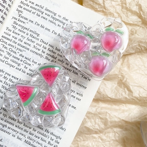 Macro shot of heart-shaped resin phone grips with 3D peach and watermelon fruit patterns