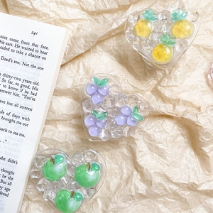 Close-up of heart-shaped fruit phone grips in pineapple, grape, and apple designs