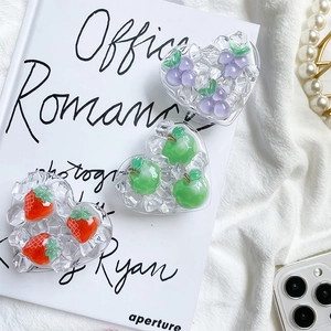 Close-up of heart-shaped resin phone grips with 3D strawberry and grape fruit inserts