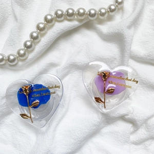Macro detail of heart-shaped phone grips with gold roses on white wrinkled fabric