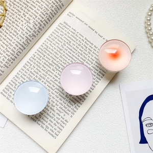 Close-up of pastel laser star glass phone grips on vintage book and pearl necklace