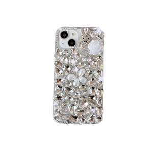Luxury rhinestone phone case featuring white resin roses, pearls, and a diamond bunny charm