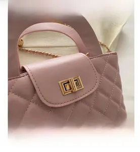 Close-up of pink quilted leather bag showing gold rotary lock and fine stitching