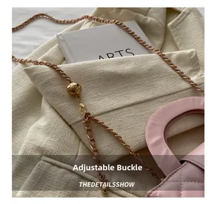 Detail of light pink quilted leather bag with adjustable golden ball chain buckle
