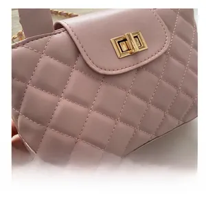 Close-up of pink quilted faux leather on flap bag with golden rotary twist lock